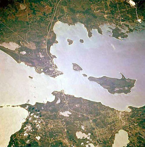 Mackinac Island is the top-left island of the three islands just to the east (right) of the Straits of Mackinac.