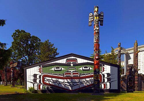 Wawadit'la, a Kwakwakaʼwakw "big house", with a totem pole in Thunderbird Park