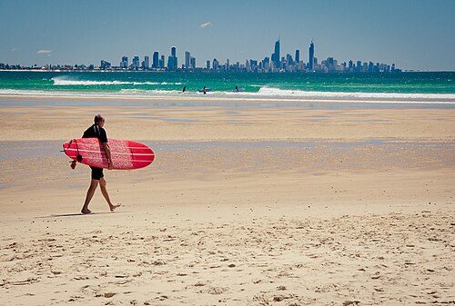 A surfer on the Gold Coast, Queensland. An iconic global image of Australian tourism focuses on its beaches, which are an integral part of the Australian identity.[1]